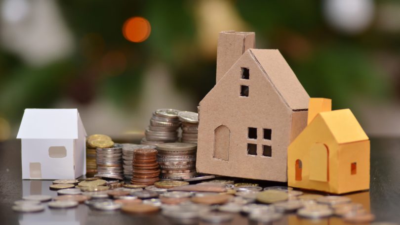 Casas de cartón en préstamos fiscales de monedas apiladas