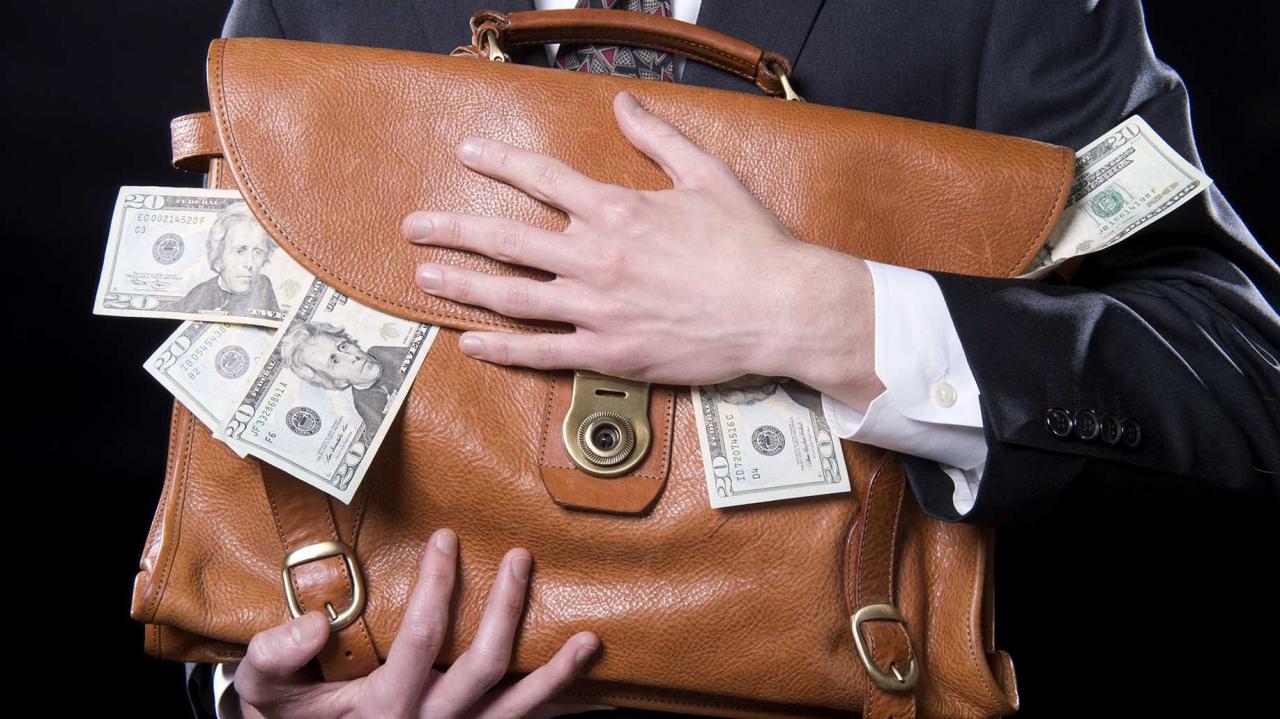 hombre sosteniendo una bolsa de dinero en efectivo