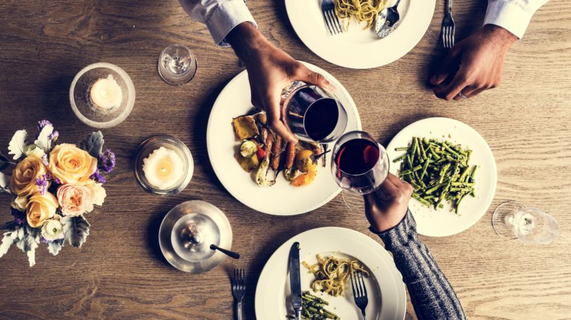 Pareja, cenar, en, restaurante, copas de vino, saludos
