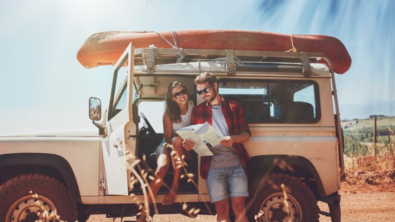 Pareja en viaje por carretera con Jeep Vintage Kayak Summer Desert