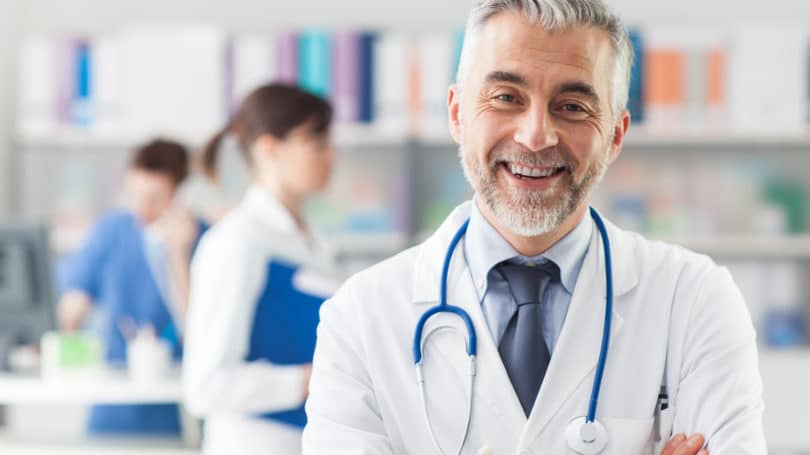 Doctor, sonriente, brazos cruzados, oficina