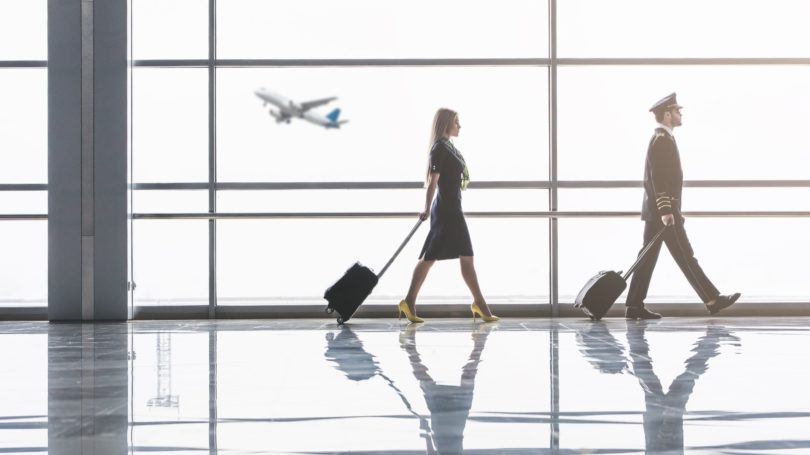 Auxiliar de vuelo caminando por el avión del aeropuerto