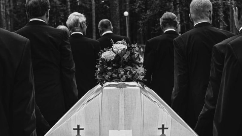 Ataúd del servicio funerario Hombres blancos negros en trajes negros