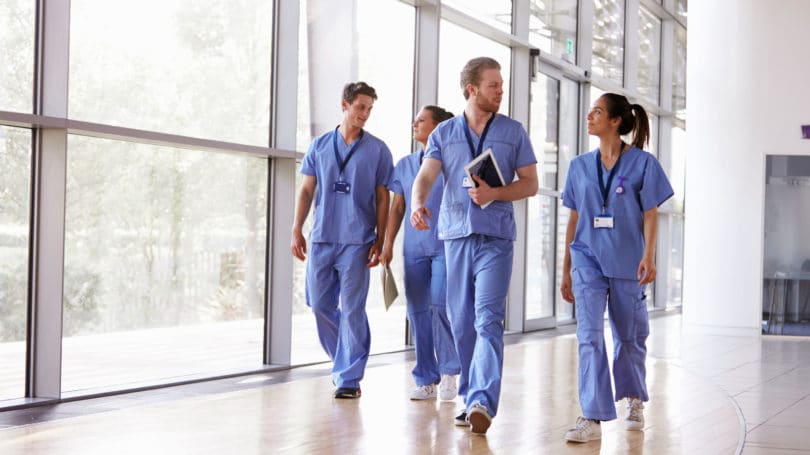 Los trabajadores sanitarios en matorrales caminando en el hospital