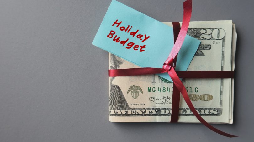 Dinero en efectivo del presupuesto de vacaciones envuelto en el fondo de compras de cinta