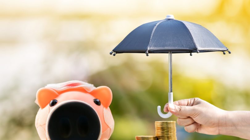 Paraguas Hurt Hurt sobre pila de monedas