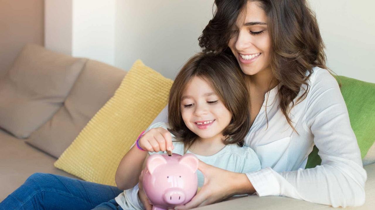 madre e hija poniendo monedas en una alcancía