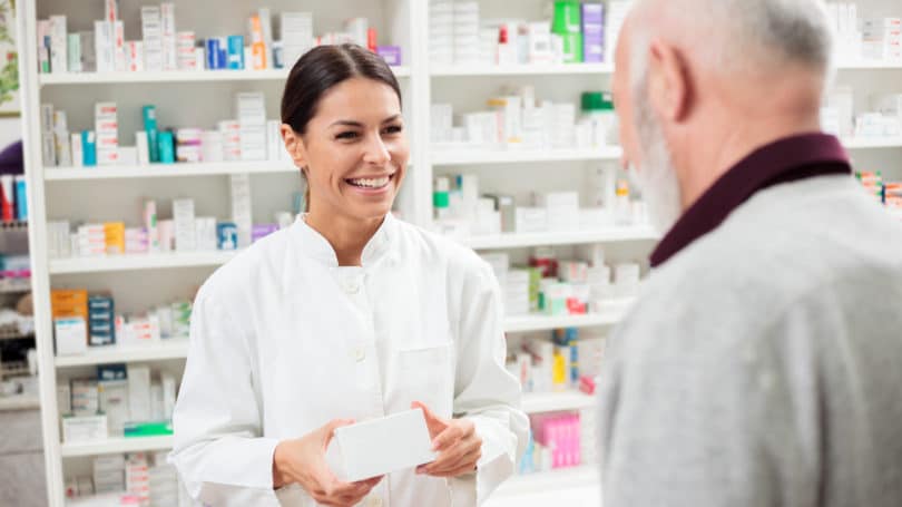 Farmacéutico dando medicamentos a la farmacia del cliente