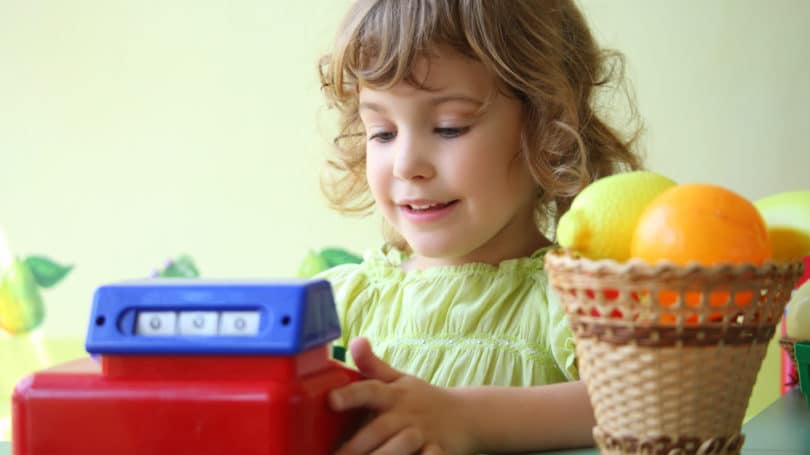 Niña sonriente jugando cajero de pretender Play Store