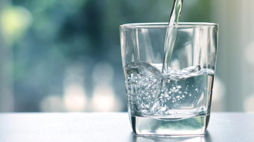 Verter agua en un vaso fresco