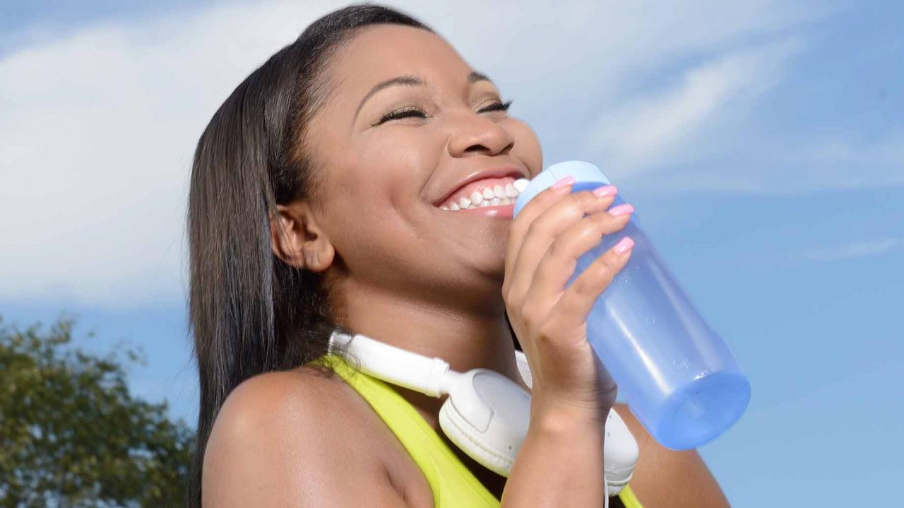 mujer con botella de agua reutilizable