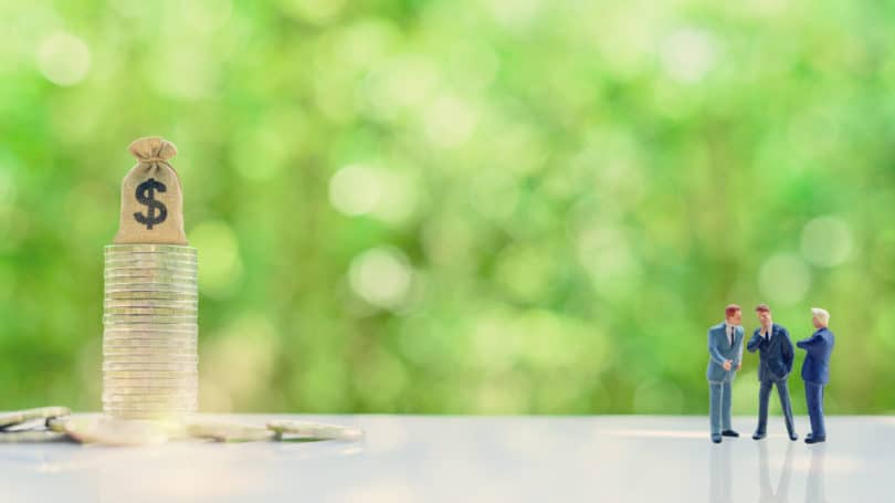 Grupo de empresarios discutiendo monedas de ingresos monetarios